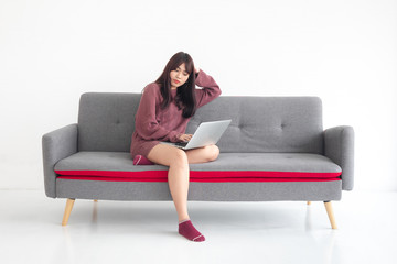 A woman sitting on a sofa watching a job on a laptop