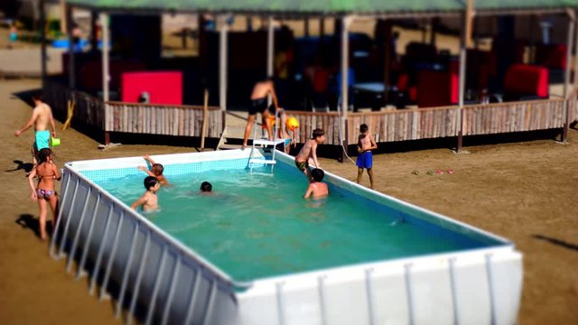 Kids playing in pool while summer time