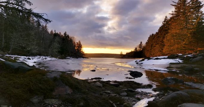 Time Lapse of cloudy sunset during winter in beautiful winter forest surrounded Cove