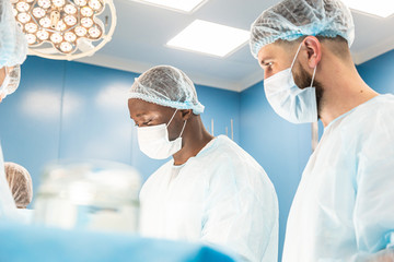 The senior surgeon in the operating room, where the patient is waiting for him, and he begins the operation. Real Modern Hospital with Authentic Equipment.