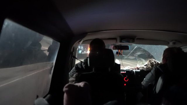 A man drives a car in the night. Car driver on the track. The view from the car oncoming traffic. Headlights in the night.