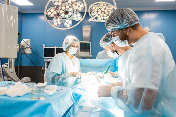 An international team of doctors performs a complex surgical operation on a patient under anesthesia. Modern operating room and experienced surgeons save lives