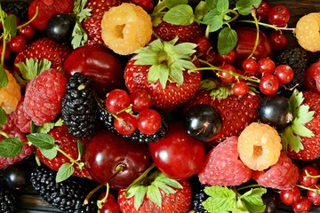 Summer berries on a wooden board close-up. Berry fruits like strawberries, blueberries, red...