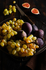 Fresh grapes and figs on an old wooden background in retro style.  Top view.