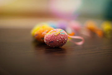 Colorful easter eggs close up on a dark wooden background. Side view, copy space for text and wording. Easter holidays concept and April vibes.