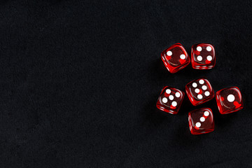 Red dice in dark black fabric background
