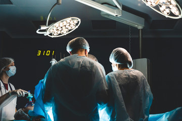 An international team of doctors performs a complex surgical operation on a patient under anesthesia. Modern operating room and experienced surgeons save lives
