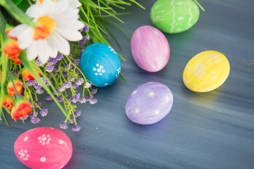 Fototapeta na wymiar Colorful easter decoration with and flowers on gray wooden table. Top view