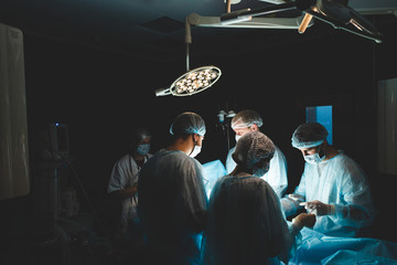 An international professional team of surgeon, assistants and anesthesiologist perform a complex...