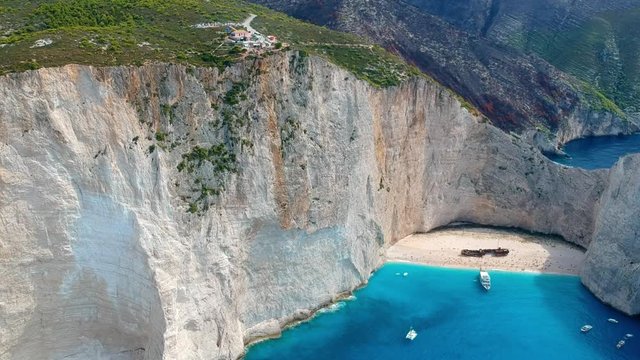Tilt down aerial shot of village and the shipwreck beach at Zakynthos