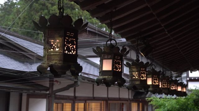 Old  nice traditional illuminated japanese lanterns on a rainy evening with a house in the background.