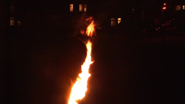 Fire breather with flames coming out of his mouth. Side view.  Street Performer at night in the dark. Stock Video Clip Footage