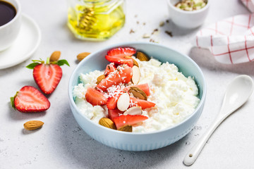 Cottage cheese with strawberry, nuts, seeds and honey. Selective focus, copy space.