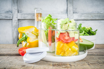 Healthy take-away lunch jar. Vegan vegetable salad in glass jars, with sliced fresh vegetables. Detox, raw eating and zero waste lunch concept