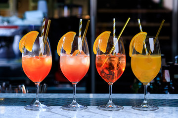 Four glasses of spritz aperitif aperol cocktail with orange slices and ice cubes