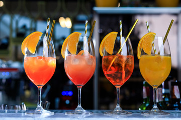 Four glasses of spritz aperitif aperol cocktail with orange slices and ice cubes