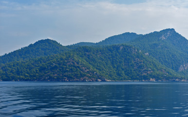 Fototapeta na wymiar blue water, blue sky, mountains. aegean. Turkey