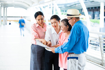 Travel and tourism concept.Group of senior people traveling in the city and looking the map in hand for Shopping Mall Search