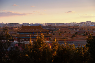 View of the Forbidden City, Beijing, China from above with beautiful sky during sunset and beautiful warm evening light. This shot was taken at Jingshan park which is centre point of Beijing.