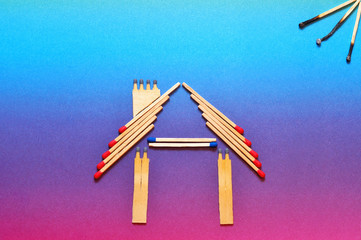 Fire insurance, Shape of house made of matches. abstract house made with matches on paper background, copy space. Concept of home protection insurance with the importance of smoke alarm systems