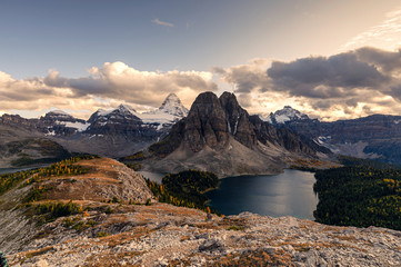 Mount Assiniboine with lake on Nublet peak in autumn forest on sunset at provincial park