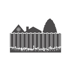 A metal fence in the backyard, behind it you can see the house and the tree.