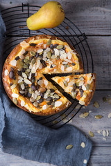 Pears and cheese pie with bowl of caramel, old spoon and fork. Top view. Copy space flat lay