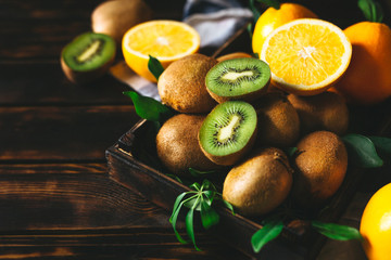  Fresh orange fruit and assorted kiwi fruit on a rustic wooden background. © Miha Creative