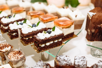 Sweet dessert table or candy bar. Table with different sweets for party. Holiday buffet with cupcakes and other desserts. Macaron, cupcakes, marshmallow close up