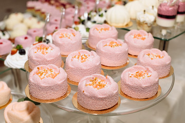 Sweet dessert table or candy bar. Table with different sweets for party. Holiday buffet with cupcakes and other desserts. Macaron, cupcakes, marshmallow close up