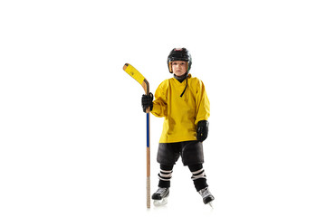 Little hockey player with the stick on ice court and white studio background. Sportsboy wearing equipment and helmet practicing, training. Concept of sport, healthy lifestyle, motion, movement, action