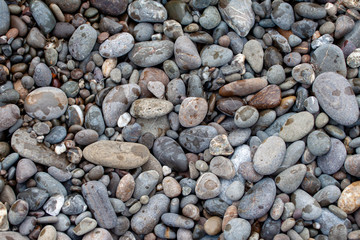 sea pebbles colored granite on the beach background stones. © mironovm