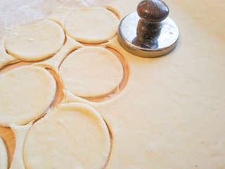 raw dough cut into circles for the preparation of pies. the process of making stuffed pies