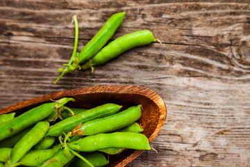 Green peas in a wooden bowl.