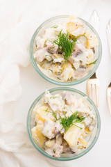 Salad rasols made of herring, cucumber and potato, dressed with mayonnaise and mustard