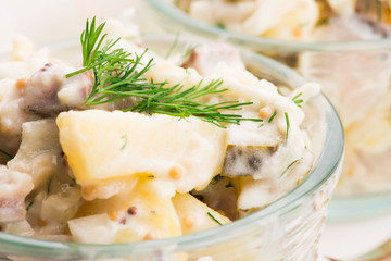 Salad rasols made of herring, cucumber and potato, dressed with mayonnaise and mustard