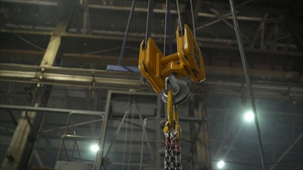 Low angle view of manual worker operating crane lifting sheet metal in industry. Crane in the...
