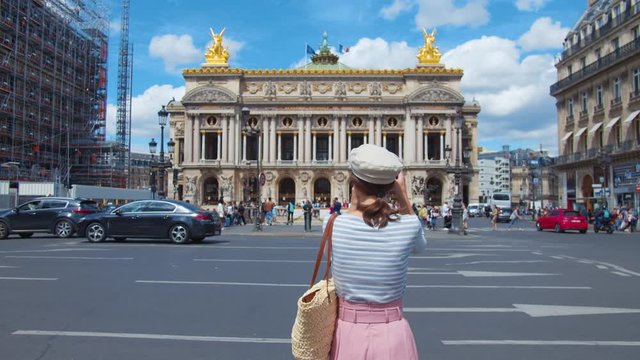 Young tourist taking photo of french opera building in Paris