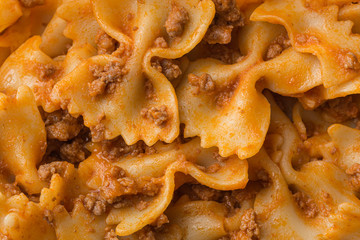Farfalle pasta with tomato bolognese sauce macro texture still