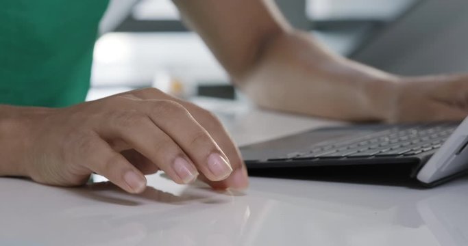 Young black business woman working with laptop computer at home. Anxious girl under stress with pc in office. Nervous African American people and technology. Close-up of fingers and keyboard