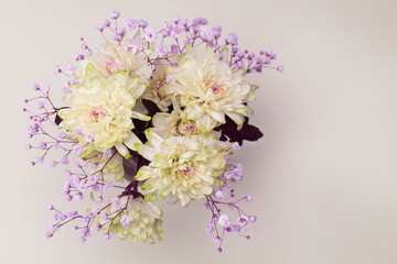 spring flowers, close-up of yellow, pale pink chrysanthemums and small lilac flowers on a soft calm empty background. Concept composition of the bouquet. copy space