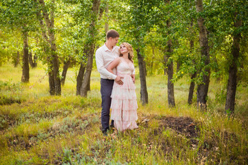 Love Story, a young couple holding hands and hugging while walking in the park.