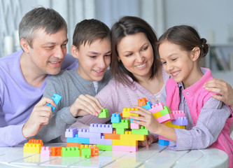 Close up portrait of happy family collecting colorful blocks