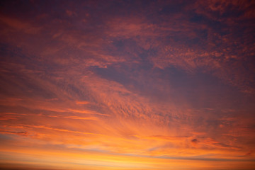 Beautiful colored cloudy skies in the colors blue, magenta, orange, purple, pink and yellow at sunrise in the Netherlands during the winter