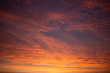 Beautiful colored cloudy skies in the colors blue, magenta, orange, purple, pink and yellow at sunrise in the Netherlands during the winter