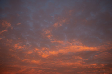 Beautiful colored cloudy skies in the colors blue, magenta, orange, purple, pink and yellow at sunrise in the Netherlands during the winter