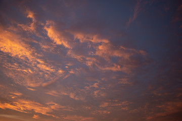 Beautiful colored cloudy skies in the colors blue, magenta, orange, purple, pink and yellow at sunrise in the Netherlands during the winter