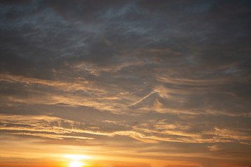 Beautiful colored cloudy skies in the colors blue, magenta, orange, purple, pink and yellow at sunrise in the Netherlands during the winter