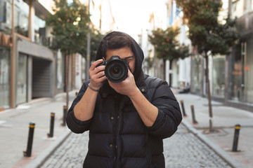 Young photographer taking photos on the streets of the city