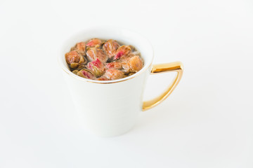 Rose herbal tea in white porcelain cup.Hot drink.White background.Minimalist style.Copy space